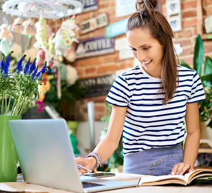 Woman on her laptop in a brightly lit shop