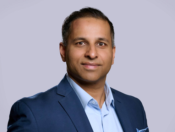 Portrait de Ronnie Prasad, employé BDC, portant un complet bleu