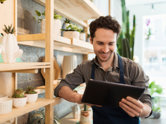 Florist using digital tablet in flower shop