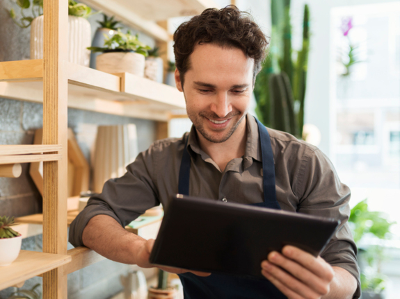 Florist using digital tablet in flower shop