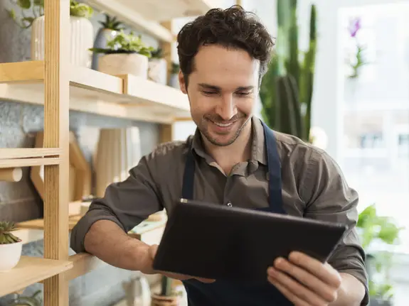 Florist using digital tablet in flower shop