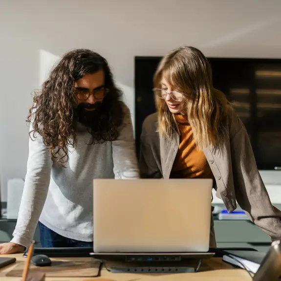 Two coworkers having a conversation in a modern office