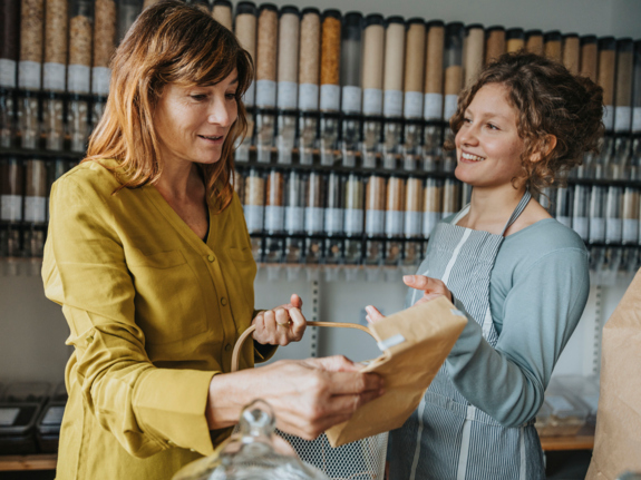 Store clerk talking to mature customer while shopping in retail store