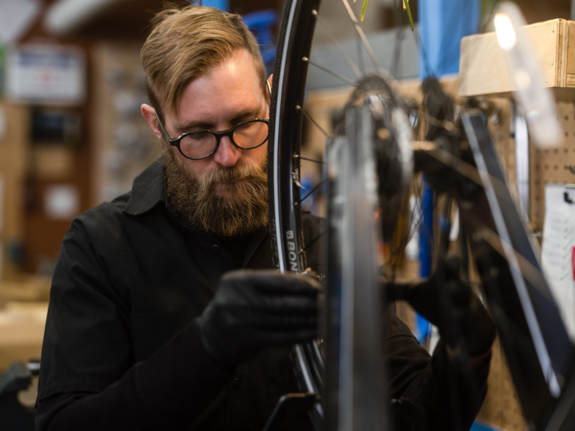 Employee wearing glasses working on a bike